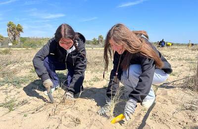 Dues noies plantant a les dunes